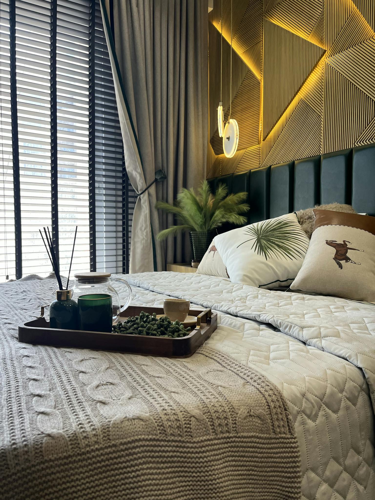 Inviting modern bedroom featuring elegant decor, warm lighting, and lush bedding.