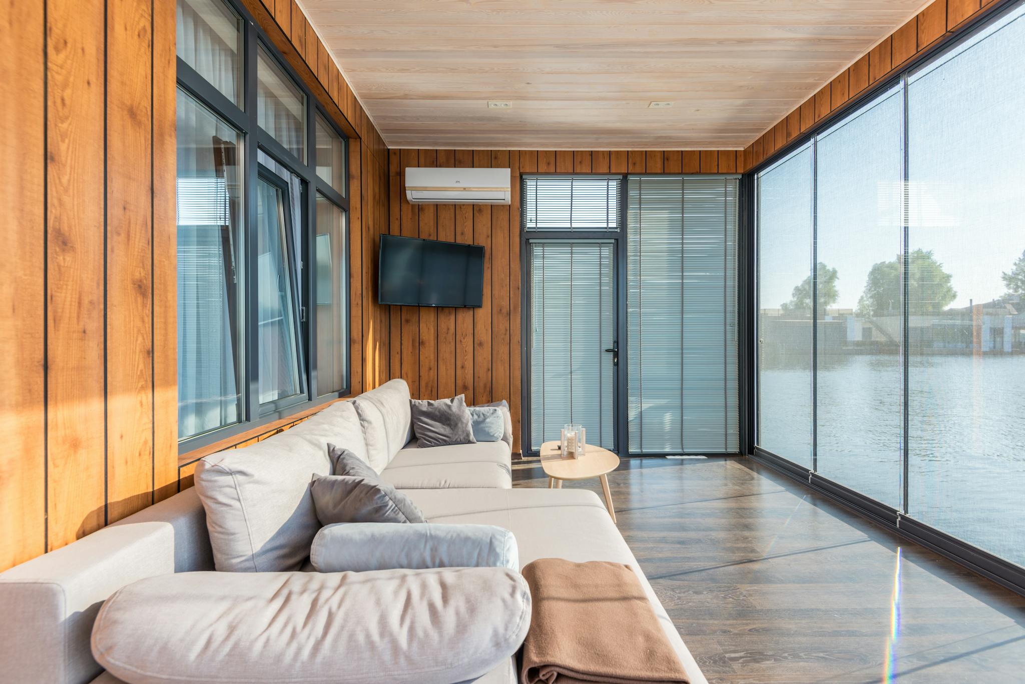 A modern room with large windows, cozy couches, and a beautiful water view.